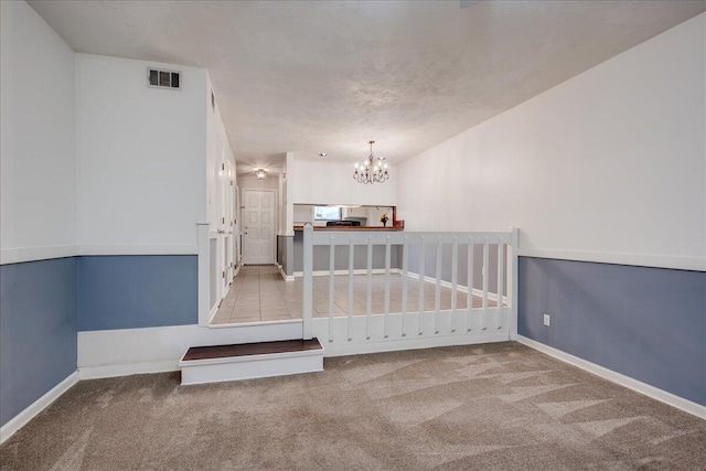 interior space featuring a notable chandelier, visible vents, and baseboards