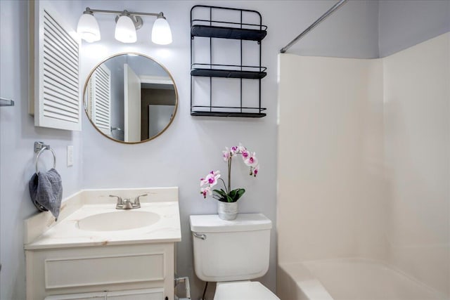 bathroom featuring toilet, vanity, and bathing tub / shower combination