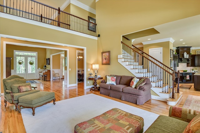 3005 Timber Woods Dr, Appling, GA 30802 - living room featuring ornamental molding, stairway, wood finished floors, french doors, and a wainscoted wall