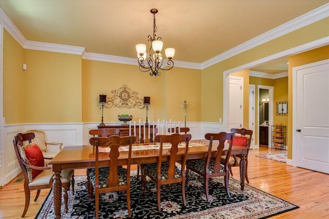 3005 Timber Woods Dr, Appling, GA 30802 - dining room featuring a chandelier, ornamental molding, light wood-type flooring, wainscoting, and a decorative wall