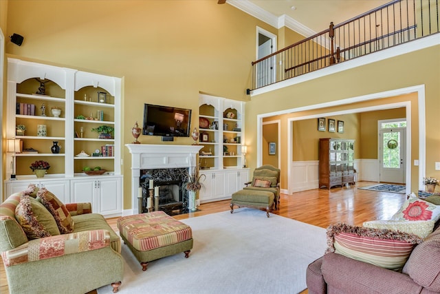 3005 Timber Woods Dr, Appling, GA 30802 - living area featuring wood finished floors, a premium fireplace, crown molding, a high ceiling, and a wainscoted wall