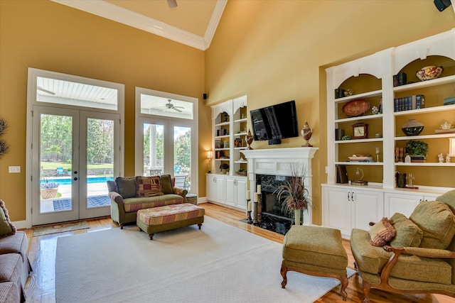 3005 Timber Woods Dr, Appling, GA 30802 - living area featuring crown molding, french doors, light wood finished floors, a fireplace, and a towering ceiling