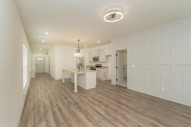 1717 Plank Rd, North Augusta, SC 29841 - kitchen featuring a kitchen breakfast bar, white cabinets, a center island with sink, stainless steel appliances, and light wood finished floors