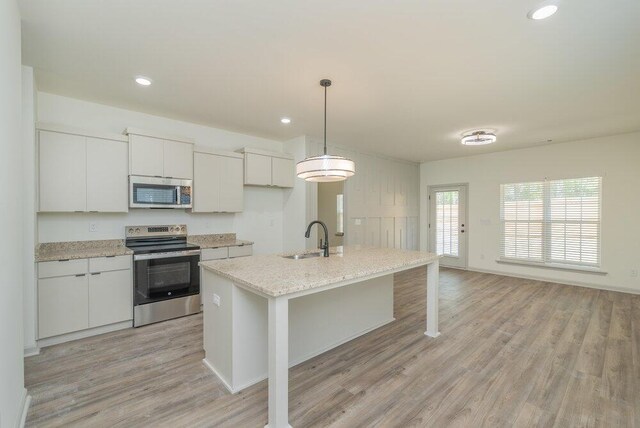 1717 Plank Rd, North Augusta, SC 29841 - kitchen featuring white cabinets, appliances with stainless steel finishes, a kitchen island with sink, a sink, and light wood finished floors
