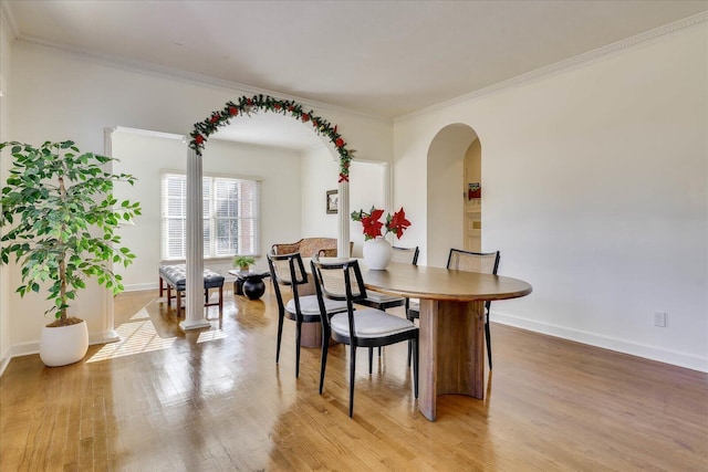 dining area with light wood-type flooring and ornamental molding