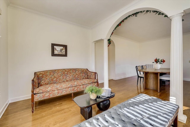 living room featuring hardwood / wood-style flooring, decorative columns, and ornamental molding