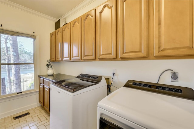 laundry area featuring ornamental molding, cabinets, and independent washer and dryer