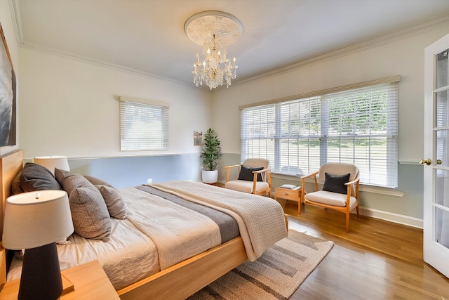 bedroom with crown molding, an inviting chandelier, and wood-type flooring