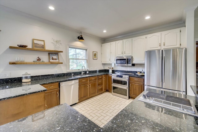 kitchen featuring sink, ornamental molding, dark stone countertops, and stainless steel appliances