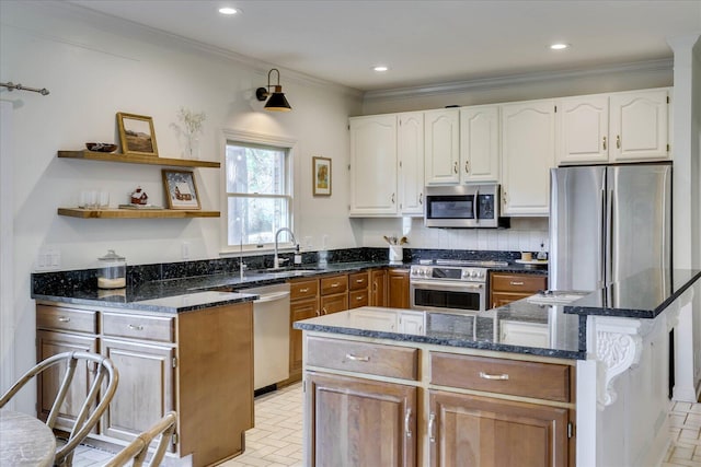 kitchen with sink, dark stone counters, a kitchen island, stainless steel appliances, and ornamental molding