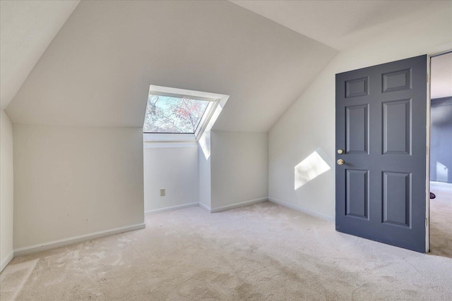 additional living space with light carpet and lofted ceiling with skylight