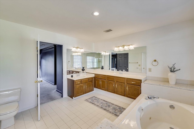 bathroom featuring toilet, tile patterned flooring, a tub to relax in, and vanity