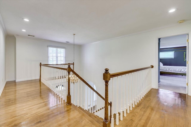 corridor featuring light hardwood / wood-style flooring and crown molding