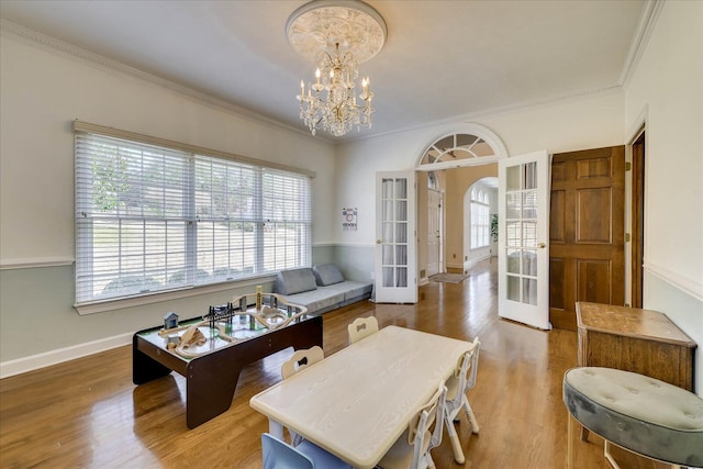 interior space featuring ornamental molding, french doors, hardwood / wood-style floors, and a chandelier