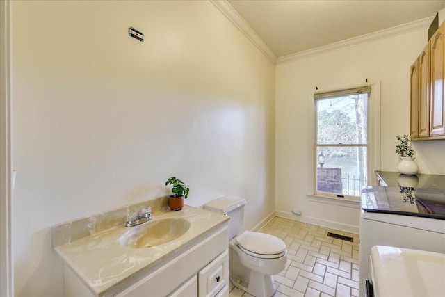 bathroom with ornamental molding, vanity, and toilet