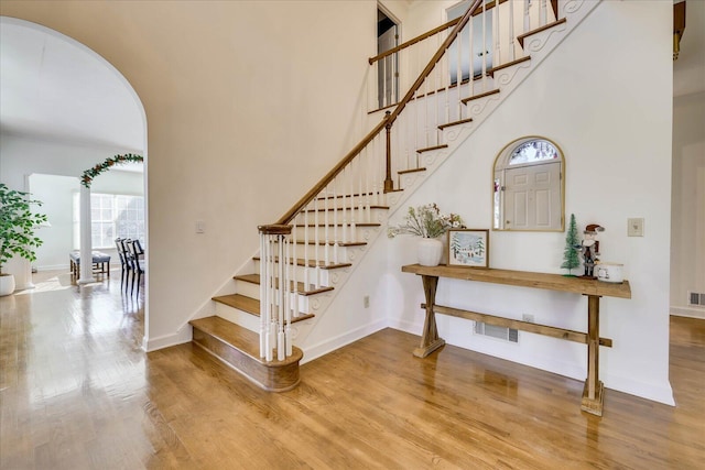 stairs featuring hardwood / wood-style floors and a high ceiling