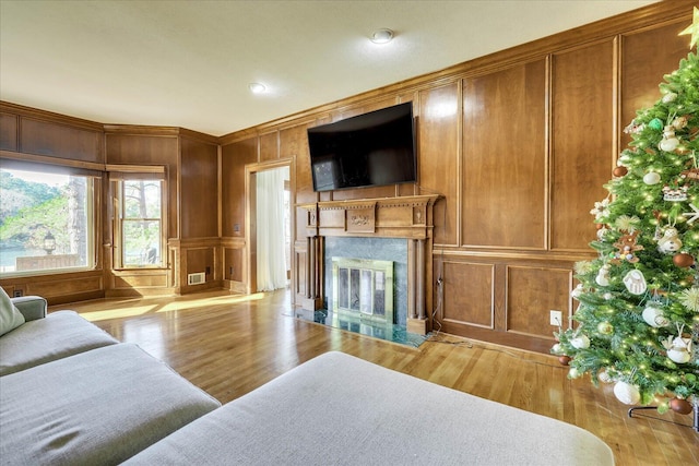 living room featuring light hardwood / wood-style floors, a premium fireplace, and ornamental molding