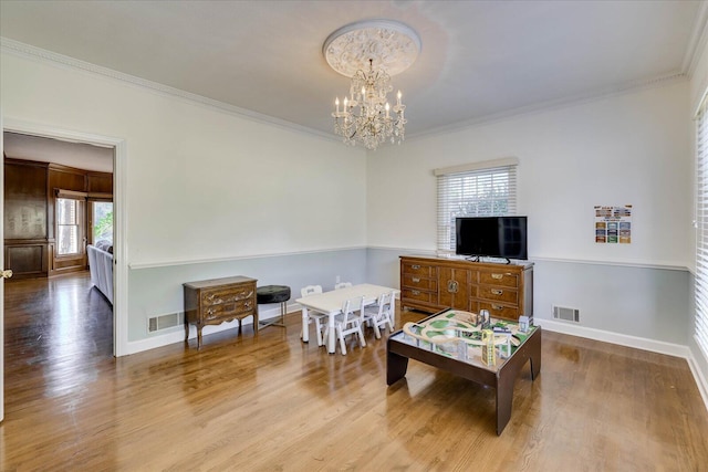 living room featuring hardwood / wood-style floors, a chandelier, and crown molding