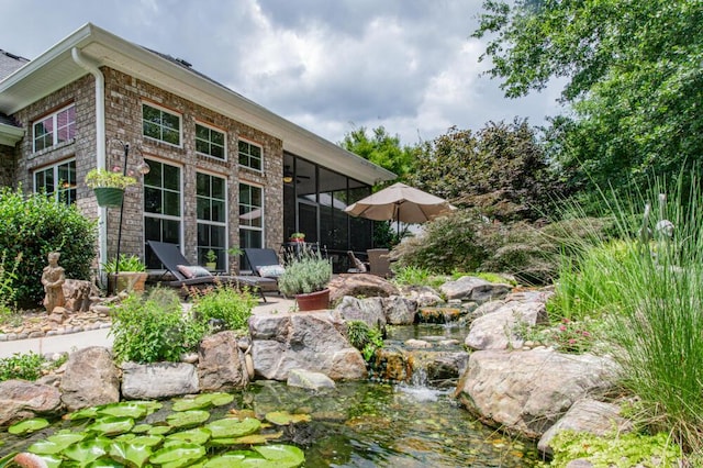 3039 Tarleton Ct, Beech Island, SC 29842 - rear view of property featuring a sunroom, a small pond, and a patio area