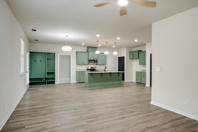 1962 Bunting Dr, North Augusta, SC 29841 - kitchen with green cabinets, appliances with stainless steel finishes, light wood-style floors, a kitchen bar, and recessed lighting