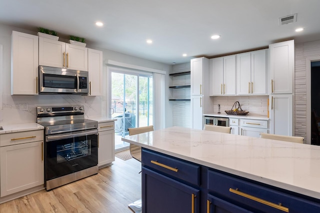 3609 Cameron Dr, Augusta, GA 30906 - kitchen featuring visible vents, blue cabinetry, stainless steel appliances, decorative backsplash, and white cabinets