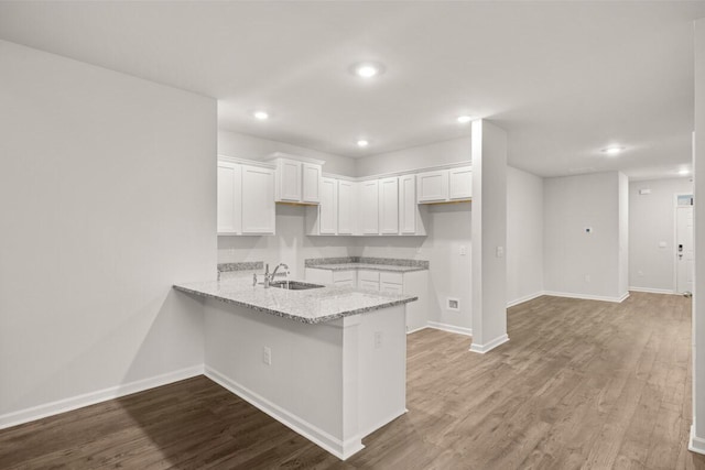 2912 Saltwater Bnd, Beech Island, SC 29842 - kitchen with sink, white cabinetry, hardwood / wood-style floors, light stone counters, and kitchen peninsula