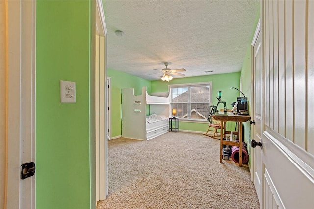 playroom with a textured ceiling, ceiling fan, and light colored carpet