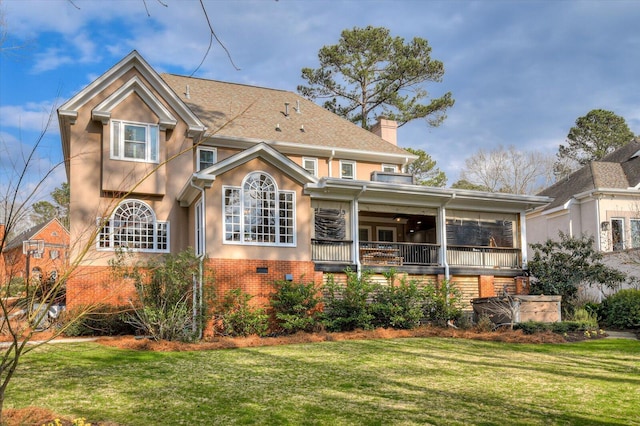 exterior space featuring brick siding, a shingled roof, stucco siding, a chimney, and a front yard