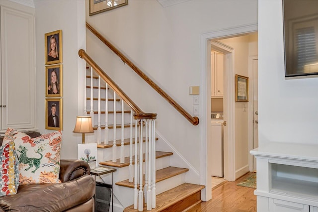 staircase with wood finished floors and washer / dryer