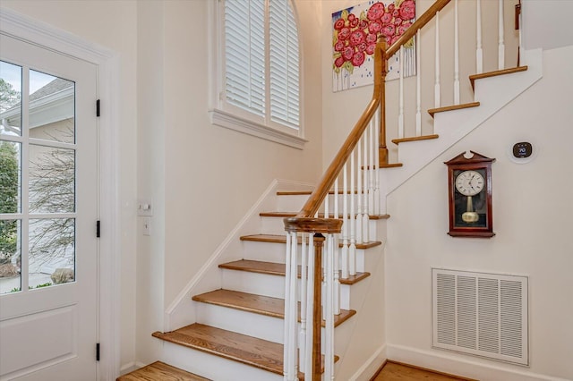 stairs with baseboards and visible vents