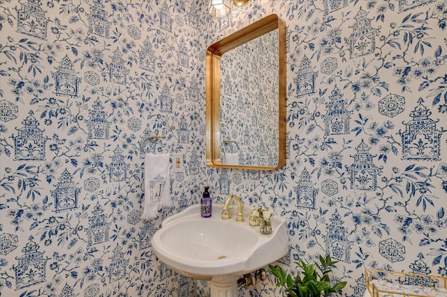 bathroom with a sink and wallpapered walls