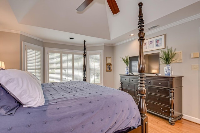 bedroom with a raised ceiling, visible vents, crown molding, and light wood-style flooring