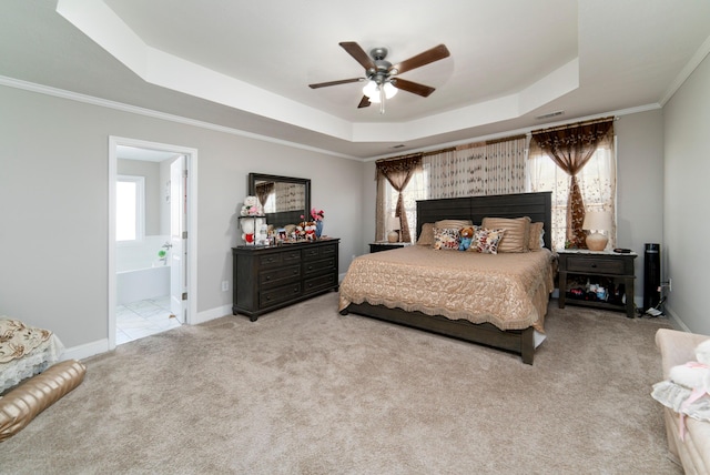 bedroom featuring light carpet, a raised ceiling, ceiling fan, crown molding, and connected bathroom