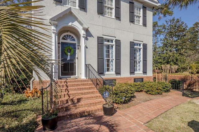 doorway to property featuring stucco siding