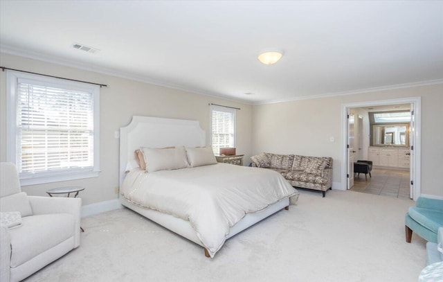 carpeted bedroom featuring ensuite bath, baseboards, visible vents, and crown molding