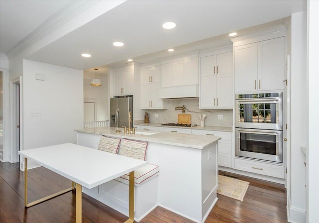 kitchen with white cabinets, dark wood-style floors, stainless steel appliances, and decorative backsplash