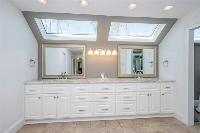 bathroom featuring lofted ceiling with skylight, recessed lighting, a sink, and double vanity