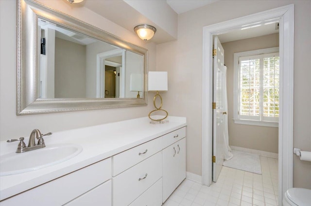 full bath with toilet, tile patterned floors, baseboards, and vanity