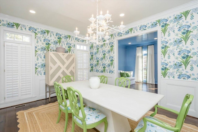 dining space with wallpapered walls, ornamental molding, and wainscoting