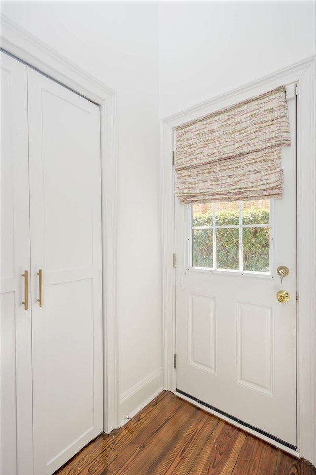 entryway with dark wood-style flooring and baseboards