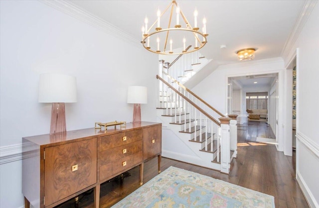 entrance foyer with a notable chandelier, stairs, ornamental molding, and wood finished floors