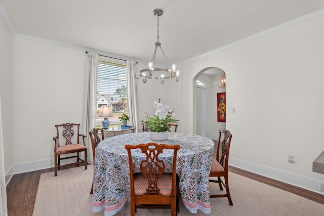 2442 Mcdowell St, Augusta, GA 30904 - dining area with crown molding, an inviting chandelier, light wood-style floors, arched walkways, and baseboards