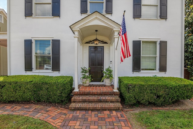 view of exterior entry featuring stucco siding