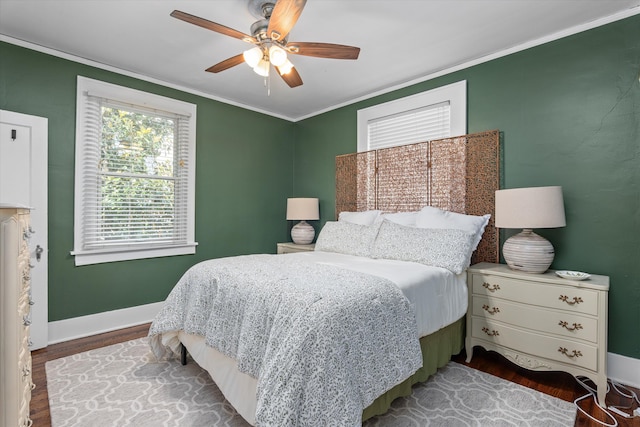 bedroom featuring crown molding, baseboards, ceiling fan, and wood finished floors