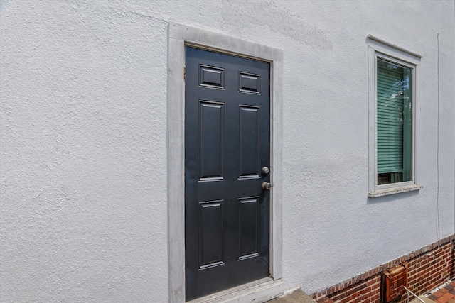 doorway to property featuring stucco siding