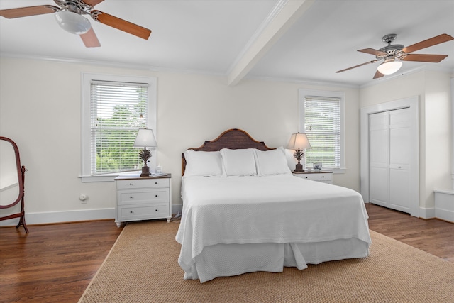 bedroom featuring crown molding, baseboards, multiple windows, and wood finished floors