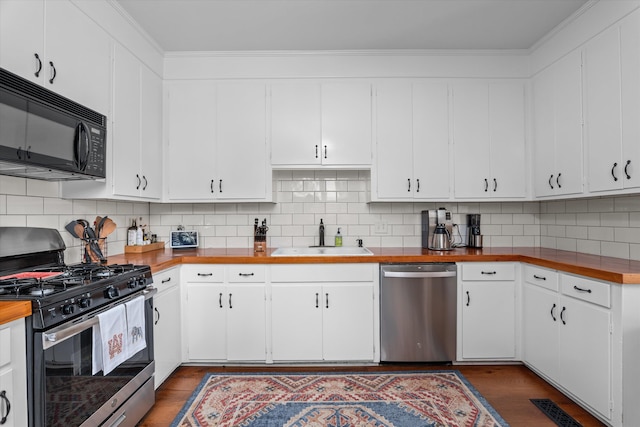 2442 Mcdowell St, Augusta, GA 30904 - kitchen with white cabinets, dark wood-style flooring, appliances with stainless steel finishes, a sink, and backsplash