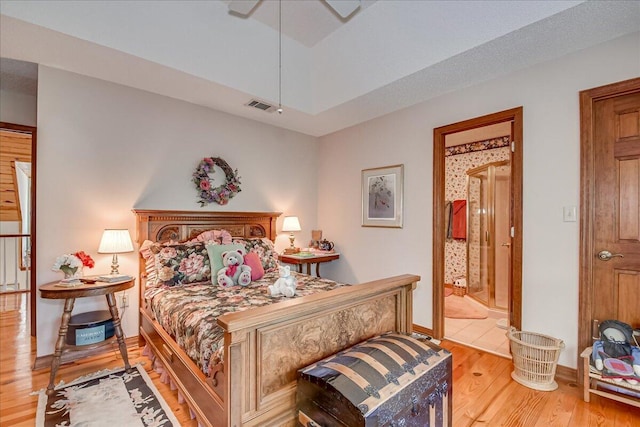 bedroom with ceiling fan, hardwood / wood-style floors, and ensuite bathroom