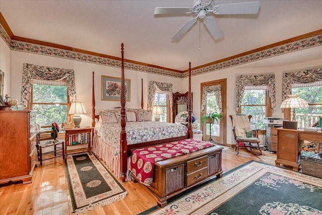 bedroom with multiple windows, wood-type flooring, and ceiling fan