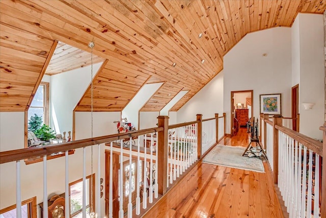 hall with light hardwood / wood-style flooring, wooden ceiling, and vaulted ceiling